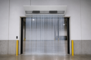 Draft review: industrial air curtain mounted above a doorway with the discharge outlet facing down